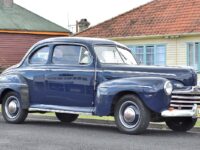 This is a blue 1946 Ford coupe, a  two-door version of the similar deluxe sedan.  Via Wikipedia